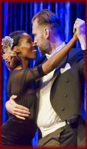 An African American lady and a bearded Caucasian Man dancing ballroom together and having a wonderful time - Dance Lessons